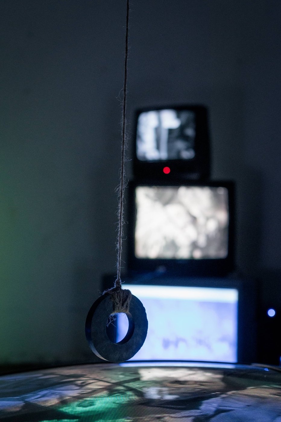 Limen installation close-up with suspended object and CRT monitors